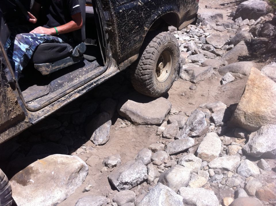 Black SUV side view navigating rocky terrain
