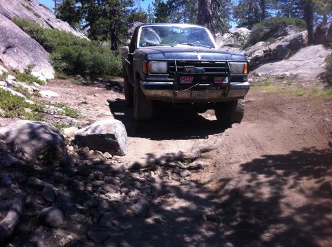 1990 Ford Bronco - This 1990 Ford Bronco navigates a , rocky trail under a clear blue sky.