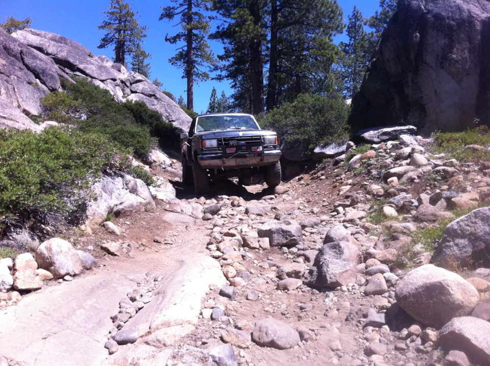 Dark gray Ford Bronco navigating a rocky, off-road trail