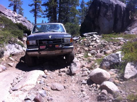 1990 Ford Bronco - Ford Bronco tackling a challenging rocky trail during an off-road adventure.