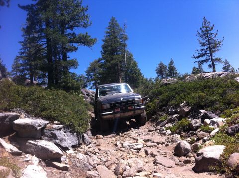 1990 Ford Bronco - This 1990 Ford Bronco tackles a challenging rocky trail under a clear blue sky.