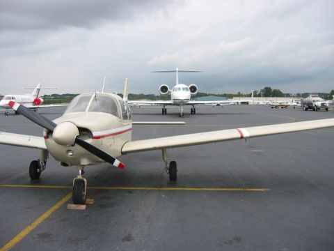 1989 Ford Bronco - A variety of aircraft, including a small propeller plane and larger jets, are visible on the tarmac.