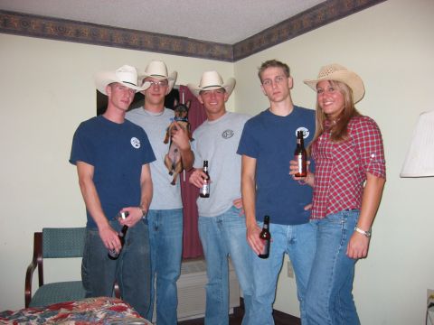 1989 Ford Bronco - A group of friends dressed in cowboy attire pose for a photo with a small dog and beer bottles.