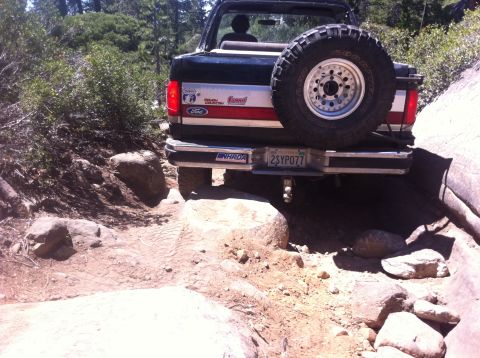 1990 Ford Bronco - This black Ford Bronco navigates a rocky trail, its rear tire mounted externally.