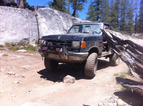 1990 Ford Bronco - 1990 Ford Bronco navigating a rocky off-road trail.