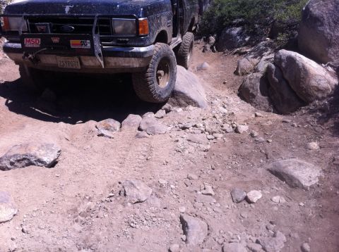 1990 Ford Bronco - Ford Bronco tackling a challenging rocky off-road path.