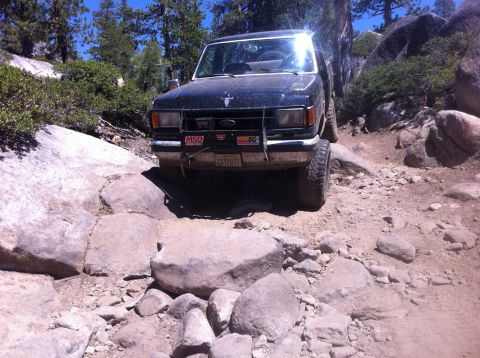 1990 Ford Bronco - Ford Bronco tackles a challenging rocky off-road path.