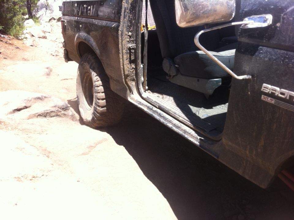 Black 1990 Ford Bronco interior and side view on rocky terrain