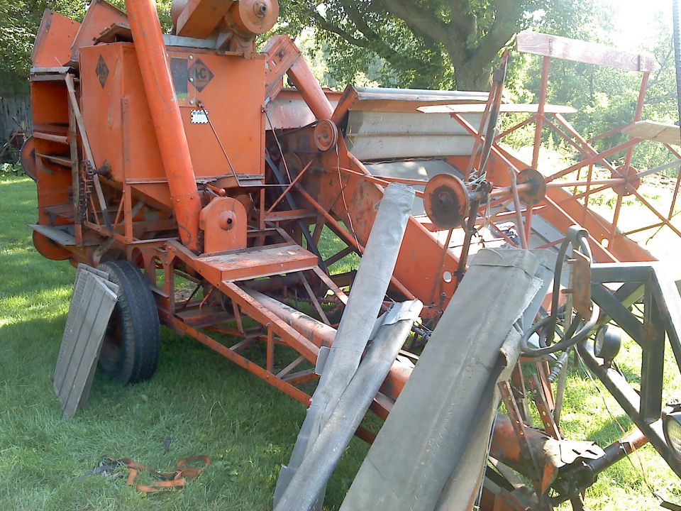 old orange combine harvester parked on grass