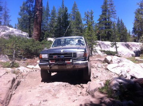 1990 Ford Bronco - This 1990 Ford Bronco navigates a challenging rocky path in a wooded area.