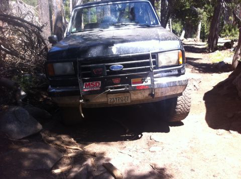1990 Ford Bronco - 1990 Ford Bronco navigating a rocky off-road trail.
