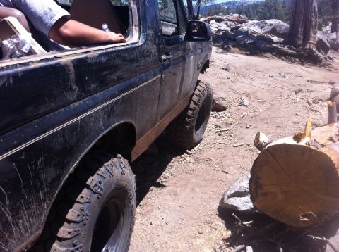 1990 Ford Bronco - This Ford Bronco is parked on a rocky, off-road trail with a fallen log nearby.