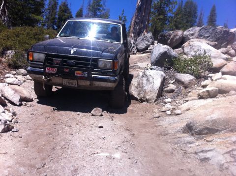 1990 Ford Bronco - This black 1980s Ford Bronco navigates a challenging rocky path during an off-road excursion.