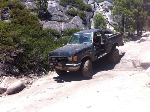 1990 Ford Bronco - This modified 1987 Ford F-150 navigates a challenging rocky terrain, its off-road capabilities.