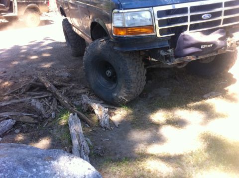 1990 Ford Bronco - Front view of a modified Ford Bronco with off-road tires, another vehicle is visible behind it.