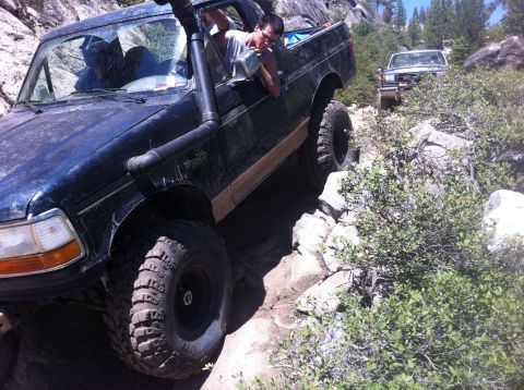 1990 Ford Bronco - Ford Bronco tackling a challenging rocky trail during an off-road excursion.