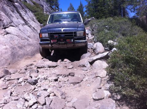1990 Ford Bronco - This 1990 Ford Bronco tackles a challenging off-road path with steep, rocky terrain.