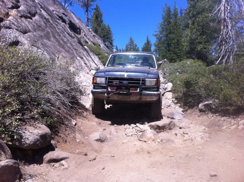 1990 Ford Bronco - Ford Bronco tackling a challenging rocky trail during an off-road adventure.