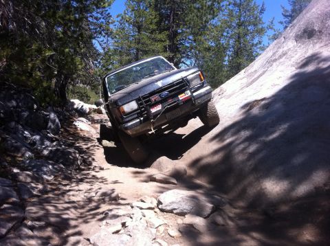 1990 Ford Bronco - This 1990 Ford Bronco tackles a challenging off-road path with steep inclines and large rocks.