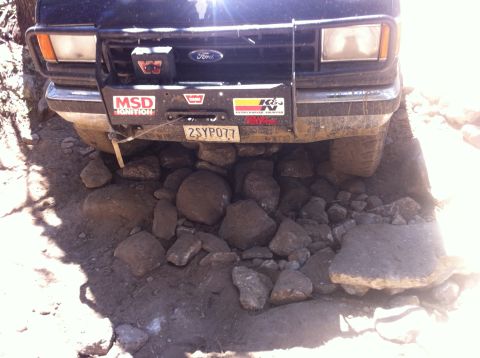 1990 Ford Bronco - This Ford Bronco is navigating a rocky trail, with its front tires high above the ground.