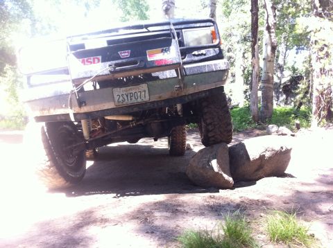 1990 Ford Bronco - This Ford Bronco is navigating a rocky trail, with its rear tires positioned on large boulders.
