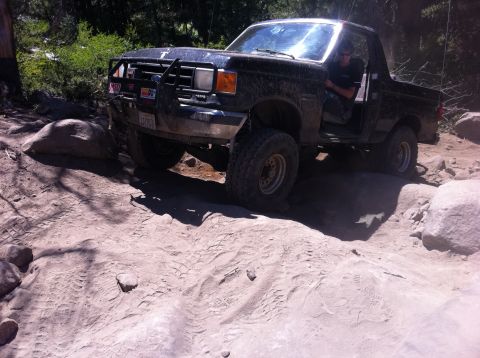 1990 Ford Bronco - This Ford Bronco is navigating a rocky off-road trail with its doors open.