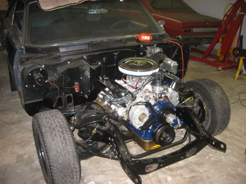 1965 Ford Galaxie - Front clip of a 1965 Ford Galaxie with engine and suspension components visible, undergoing work.