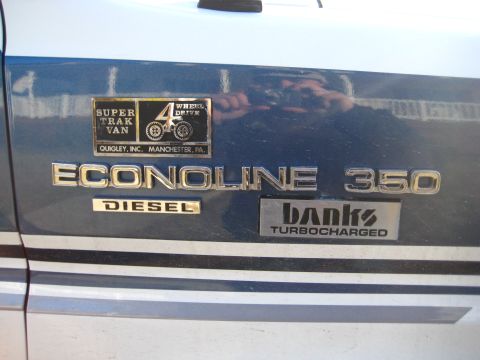1988 Ford E350 - Close-up of a Ford Econoline 350 Diesel van's side panel, showing badges for 4WD and turbocharging.