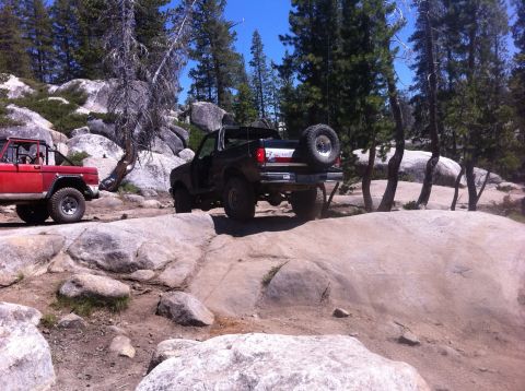 1990 Ford Bronco - Two Ford Broncos navigate a challenging rocky off-road course.