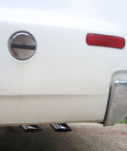 1976 Ford Ranchero - Close-up of the rear of a white 1976 Ford Ranchero, highlighting its dual exhaust system and chrome bumper.