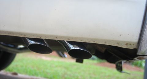 1976 Ford Ranchero - Dual exhaust pipes visible on the underside of a white vehicle.