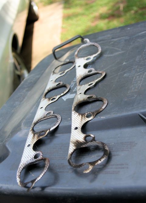 1976 Ford Ranchero - Used exhaust manifold gaskets are shown resting on a dark surface.