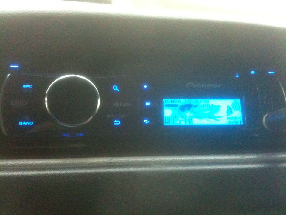 Car dashboard with a Pioneer stereo displaying a blue screen with text and graphics