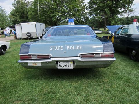 1991 Ford LTD Crown Victoria - Rear view of a light blue State Police sedan with STATE POLICE lettering and license plate 86021 parked on grass.