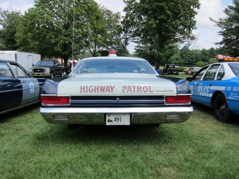 1991 Ford LTD Crown Victoria - Rear view of a vintage silver Highway Patrol sedan reading HIGHWAY PATROL, parked on grass between other police cars at a show.