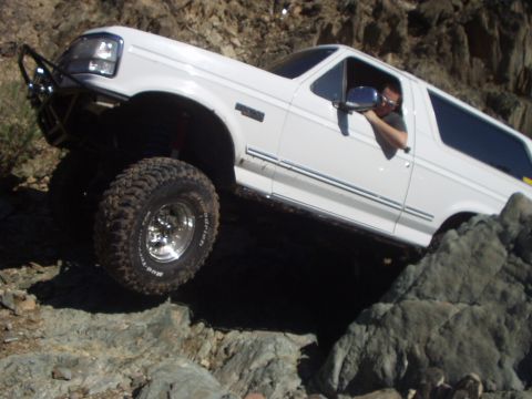 1993 Ford Bronco - White 1993 Ford Bronco navigates rocky terrain during an off-road excursion.