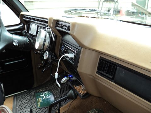 1986 Ford Bronco - The interior of a 1986 Ford Bronco shows aftermarket gauges and a modern stereo system.