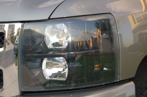 2007 Chevrolet Silverado 1500 - Close-up of a modified headlight assembly on a truck, a darkened lens.