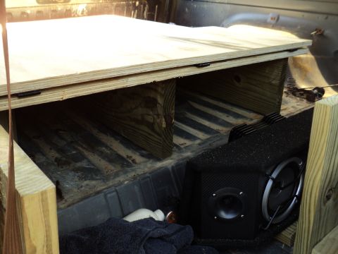 1986 Ford Bronco - Custom wooden platform and subwoofer installed in the bed of a truck.