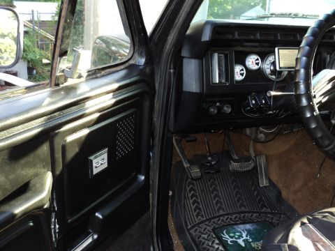 1986 Ford Bronco - Interior of a 1980s Ford truck, aftermarket gauges and a worn steering wheel.