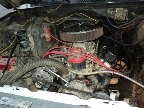 1986 Ford Bronco - The engine bay of a vehicle shows a V8 engine with various components and wiring.