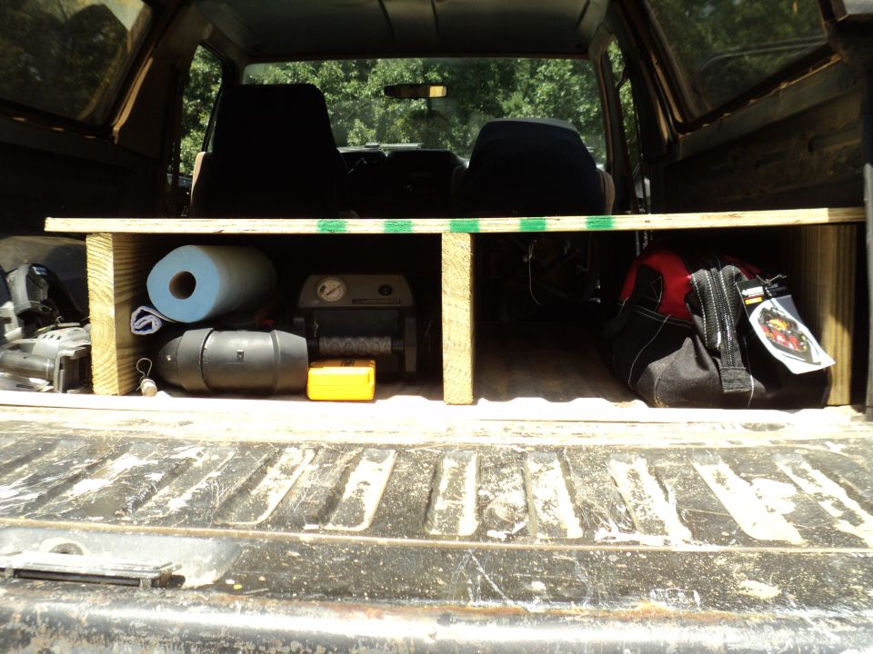 Interior cargo area with tools, paper towels, and a red and black bag
