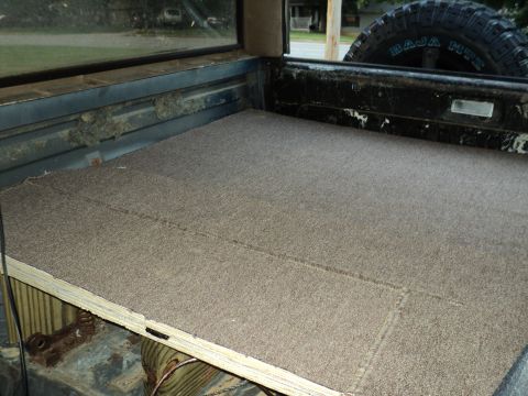 1986 Ford Bronco - Interior view of a carpeted truck bed, showing the spare tire mounted at the rear.