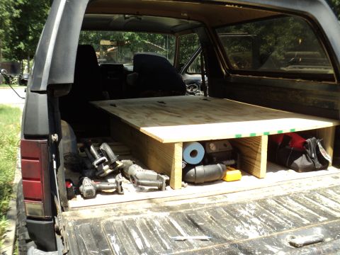 1986 Ford Bronco - The interior of a 1986 Ford Bronco features a custom wooden platform and various tools.