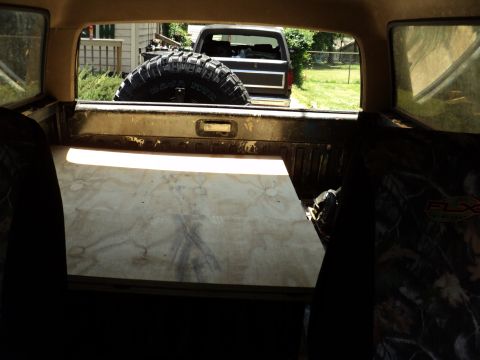 1986 Ford Bronco - View from inside a 1986 Ford Bronco shows the rear of another vehicle and a spare tire.
