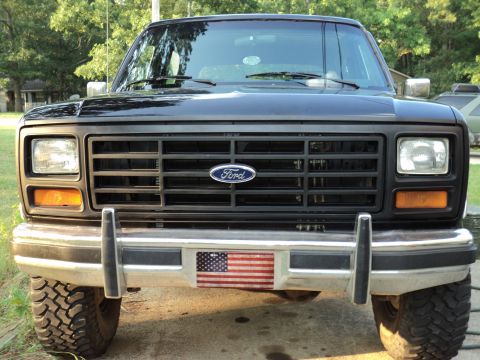 1986 Ford Bronco - This Ford truck features a prominent grille and a patriotic bumper sticker.
