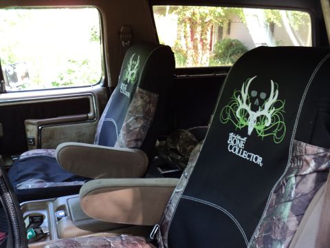 1986 Ford Bronco - The interior of the vehicle shows custom seat covers with a skull graphic and camouflage accents.