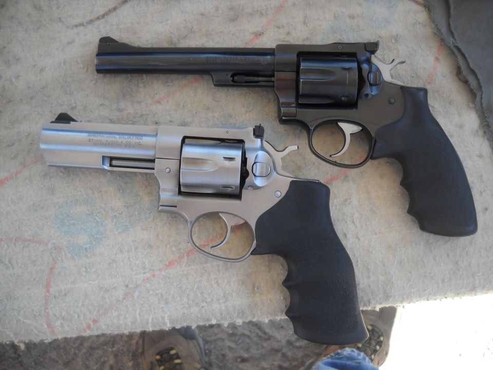 Two revolvers, one stainless steel and one black, are shown side-by-side