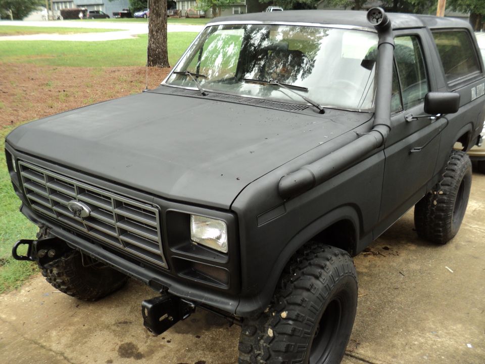 Black Ford Bronco with snorkel intake and off-road tires parked outside