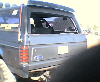 1987 Ford Bronco - Rear view of a gray 1987 Ford Bronco, showing its taillights and Ford emblem.